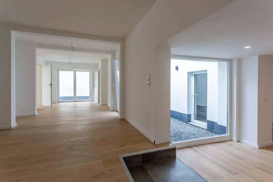 Wohnraum mit Holzboden und Durchblick ins Atrium