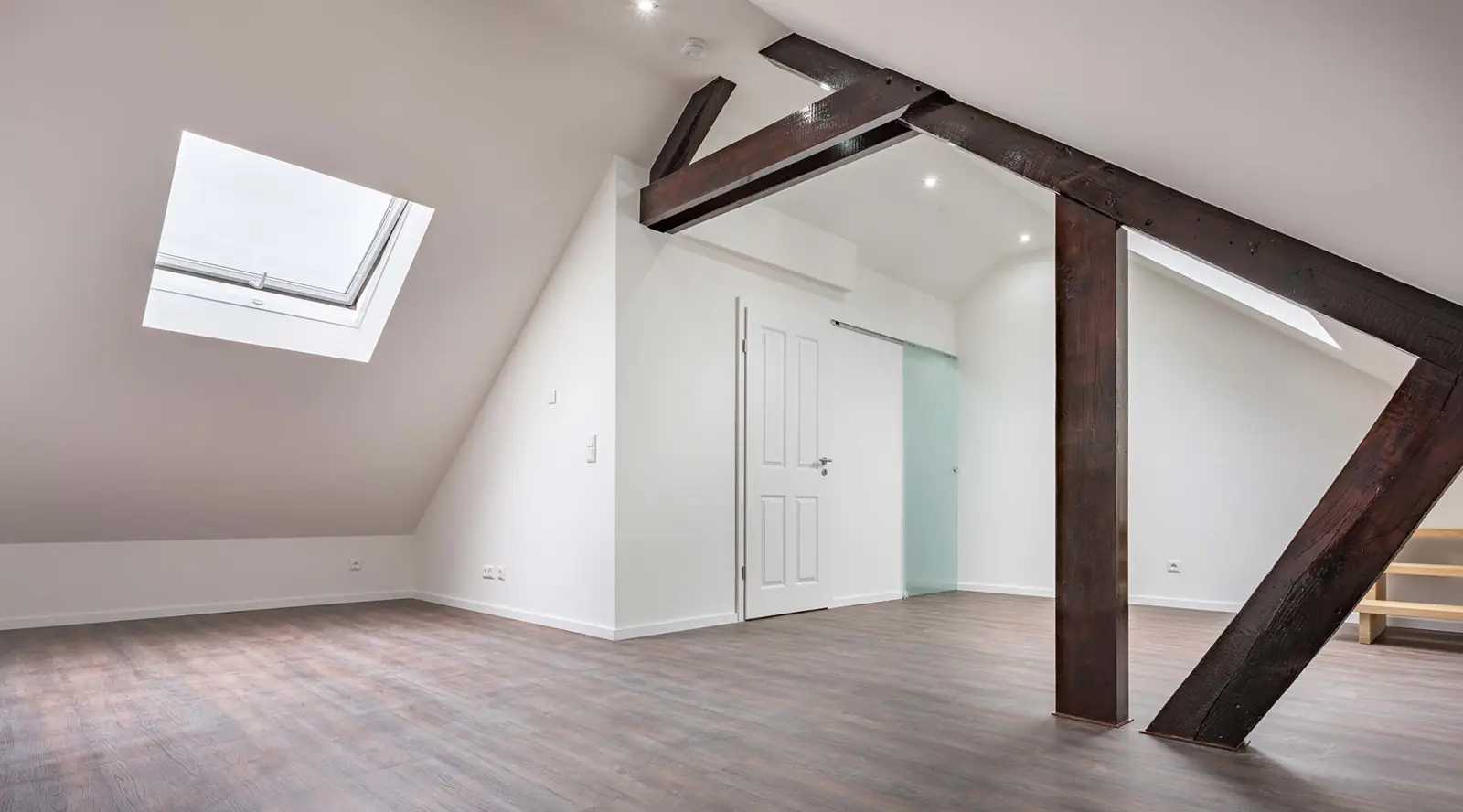 Dachgeschoss mit Holzbalken und Dachfenster im Gründerhaus