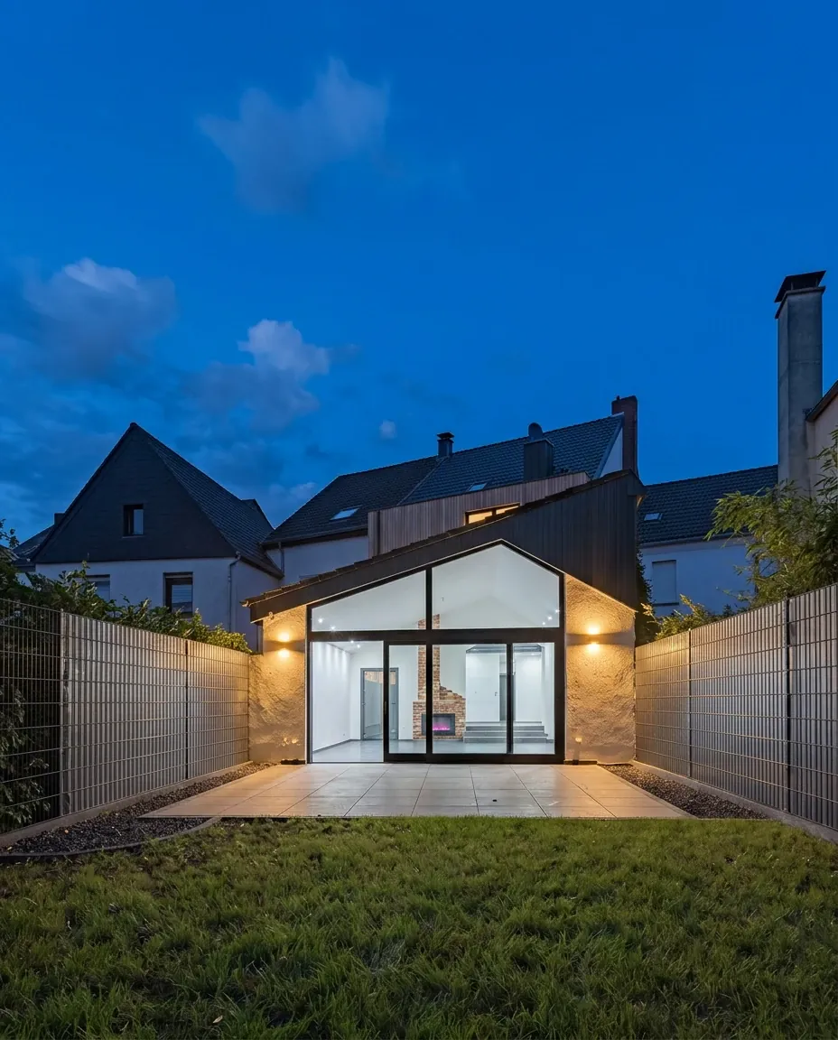 Gartenhaus des Gründerhauses von 1910 in der Abenddämmerung, mit beleuchtetem Glasgiebel